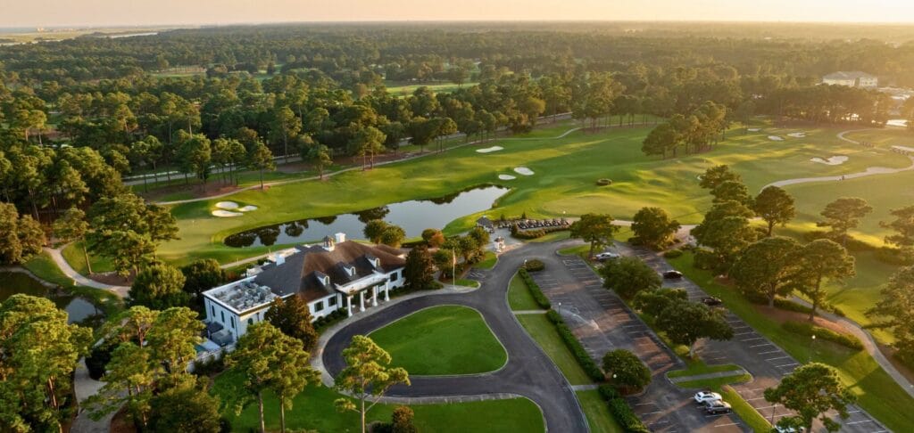 Aerial view of Porters Neck Country Club with clubhouse, golf course, and lush green landscape.