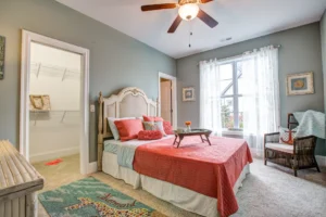 Cozy coral and teal bedroom with natural light and elegant decor.