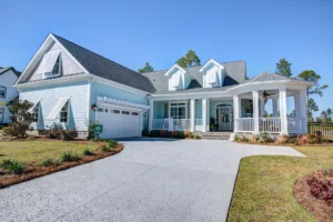 Light blue suburban home with white trim, wraparound porch, and landscaped front yard.