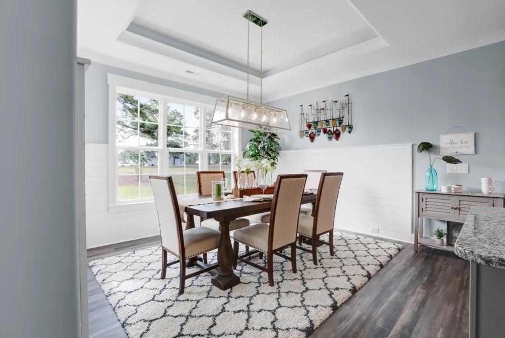 Elegant modern dining room with wooden table, beige chairs, and bright natural light.