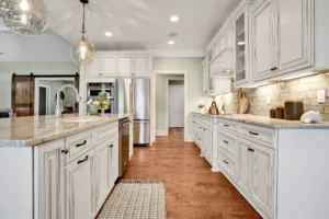 Bright galley kitchen with cream cabinets, quartz countertops, and stainless-steel appliances.