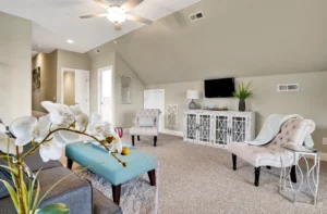 Modern neutral living room with beige walls, turquoise accents, gray sofa, and natural light.