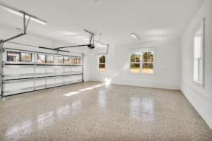 Bright modern two-car garage with white walls, epoxy floor, and natural sunlight.