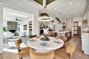 Bright modern open-concept kitchen and dining area with white, gold, and warm neutral accents.