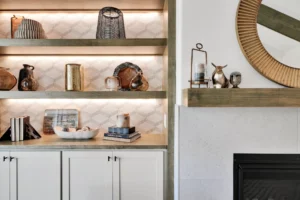 Modern living room with built-in wood shelves, warm lighting, and elegant fireplace mantel decor.