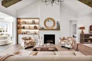 Modern cozy living room with vaulted ceilings, white fireplace, wooden beams, and natural light.