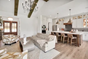 Bright open-concept living room and kitchen with exposed wood beams and modern farmhouse decor.