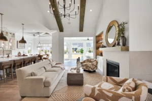 Bright modern open-concept living room with vaulted ceiling, fireplace, and seamless kitchen design.