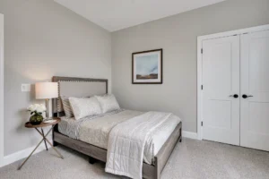 Cozy modern bedroom with neutral tones, minimalist decor, and soft gray walls.