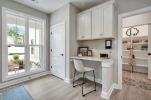 Bright modern home office with built-in white desk, natural light, and minimalist design.