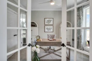 Elegant home office with French doors, rustic desk, and soft neutral décor filled with natural light.