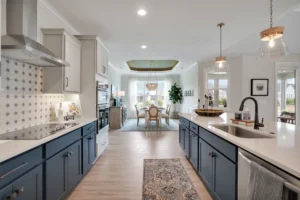 Modern open-concept kitchen with navy cabinets, quartz island, and bright dining area.