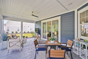 Modern covered patio with outdoor dining set, lounge seating, and stylish greenery.