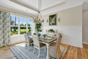 Bright coastal dining room with rustic wood table, wicker chairs, and natural light.