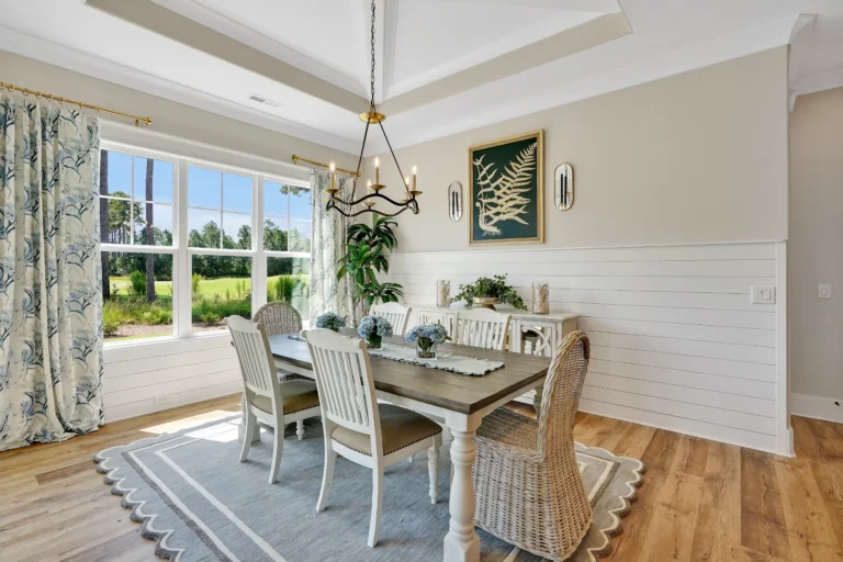 Bright coastal dining room with rustic wood table, wicker chairs, and natural light.