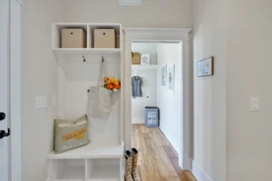 Bright modern entryway with built-in bench, woven baskets, and warm wood flooring.