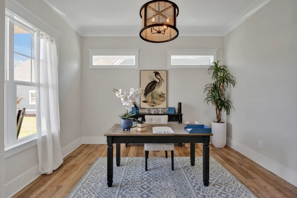 Bright modern home office with wooden desk, gray walls, natural light, and minimalist decor.