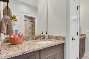 Modern bathroom with granite countertop, wood vanity, and elegant neutral décor.
