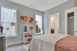 Cozy blue-gray bedroom with terracotta accents, white trim, and soft natural light.