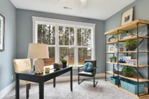 Modern cozy home office with natural light, sleek desk, and calming blue-gray walls.