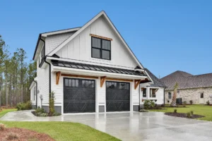 Modern white farmhouse with black trim, gabled roof, and two-car garage in suburban setting.