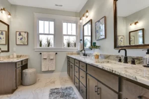 Modern bathroom with marble double vanity, warm wood cabinets, and elegant natural light.