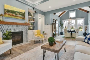 Open-concept living and dining room with tiled fireplace, light wood floors, and cozy modern decor.