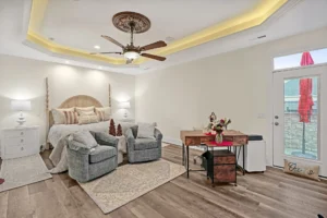 Modern cozy bedroom with wood accents, gray seating area, and warm ambient lighting.