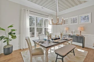 Bright modern farmhouse dining room with light wood accents and elegant bronze chandelier.