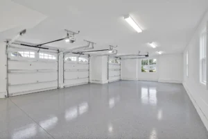 Spacious modern garage with white walls, gray epoxy floor, and bright natural and LED lighting.