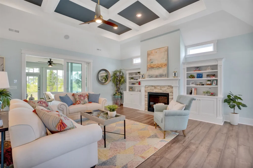 Airy coastal living room with white coffered ceiling, navy accents, fireplace, and modern decor.