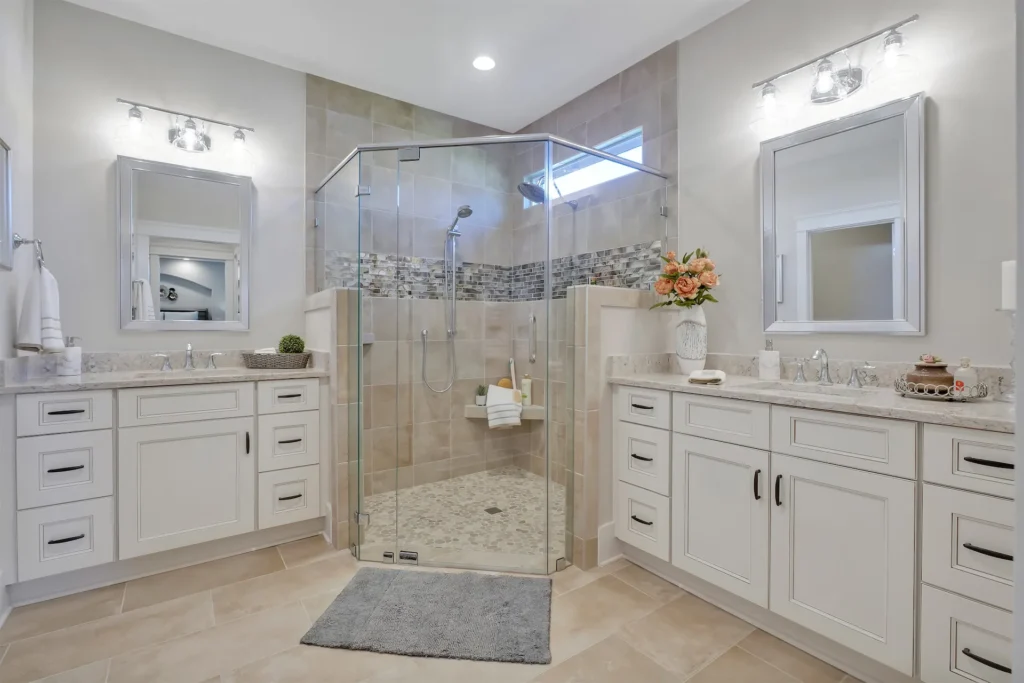 Let Us Reintroduce Ourselves 17 Elegant modern bathroom with frameless glass shower, white vanities, and light tile flooring.