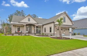Modern suburban home with beige exterior, lush lawn, front porch, and elegant landscaping.