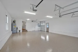 Bright modern garage interior with polished epoxy floor, glass door, and clean organized layout.