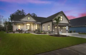 Modern suburban home exterior at dusk with warm lights and elegant landscaping.