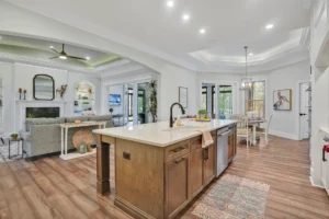 Open-concept modern farmhouse kitchen and living room with wood island, fireplace, and natural light.