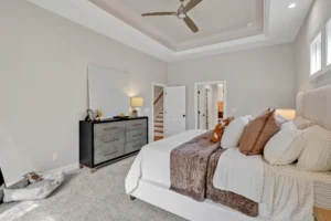 Modern beige and gray bedroom with coffered ceiling, white bed, and cozy elegant décor.