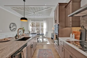 Modern warm wood kitchen with marble island, black accents, and sunlit dining area.
