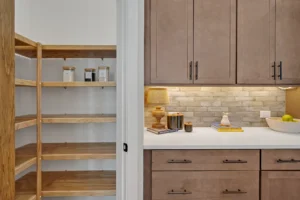 Modern kitchen with open pantry, wood cabinets, white quartz countertops, and brick backsplash.