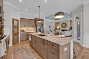 Modern open-concept kitchen and living room with granite island, warm wood accents, and cozy décor.