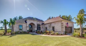 Modern white brick home with arched entryway, palm trees, and American flag in Wilmington NC.
