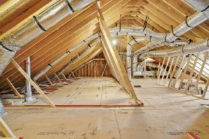Unfinished attic with new wooden framing, plywood floor, and insulated HVAC ductwork installation.