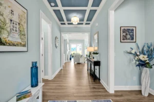 Modern coastal hallway with pastel blue walls, wood floors, and elegant décor accents.