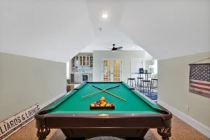 Elegant home game room with green pool table, bar area, and American flag decor.