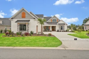 Modern suburban house with stone accents, palm tree, and inviting landscaped front yard.