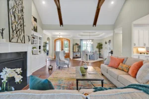 Modern open-concept living room with beige sectional sofa, fireplace, hardwood floors, and vaulted ceilings.