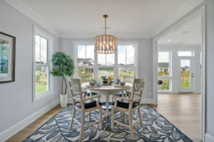 Bright coastal dining nook with round wooden table, lattice chairs, and natural light.