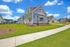 Light blue corner home with white trim and lush lawn in sunny Wilmington neighborhood.