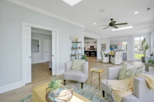 Bright modern coastal living room with light wood floors, gray furniture, and airy natural accents.