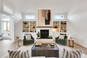 Bright modern living room with fireplace, green armchairs, neutral decor, and natural light.